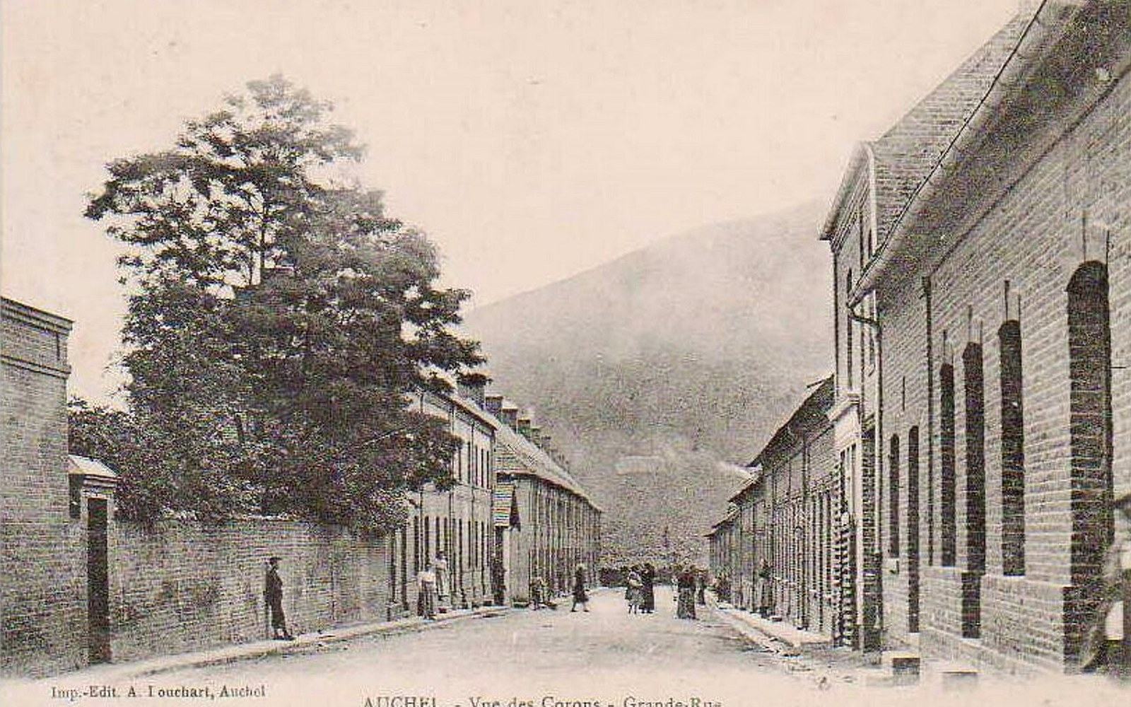 A brick terraced street with a belfry at the end
